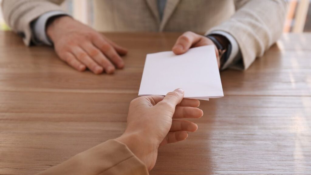 Pessoa segurando carta de demissão. Imagem ilustrativa para texto Pedir demissão direitos.