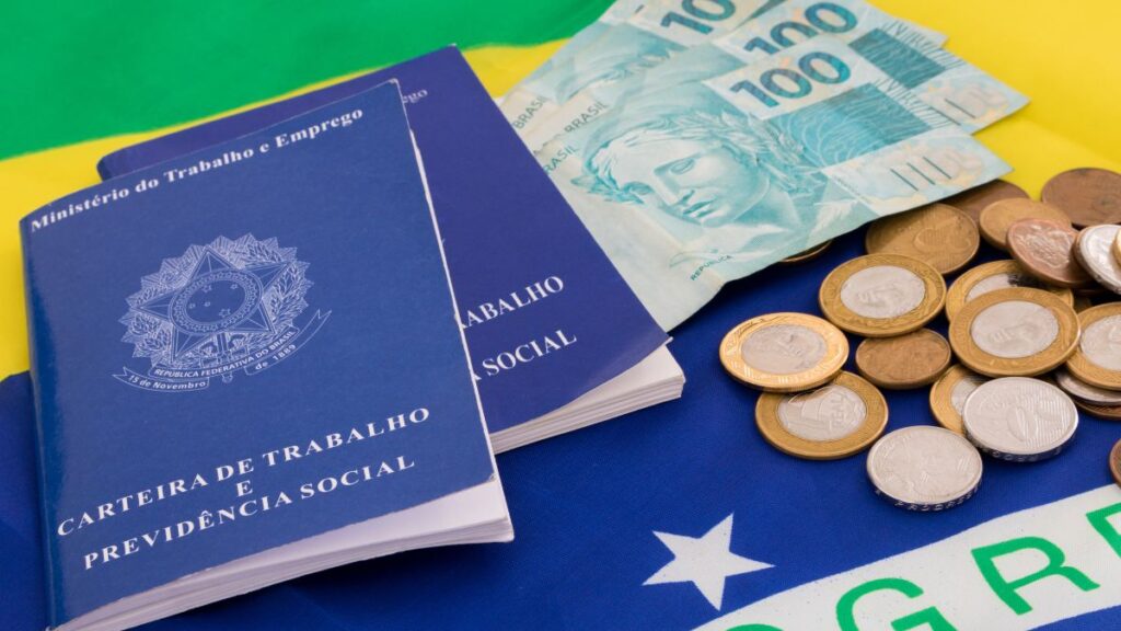 Imagem de bandeira do Brasil, dinheiro e carteira de trabalho. Imagem ilustrativa para texto Nova reforma trabalhista.