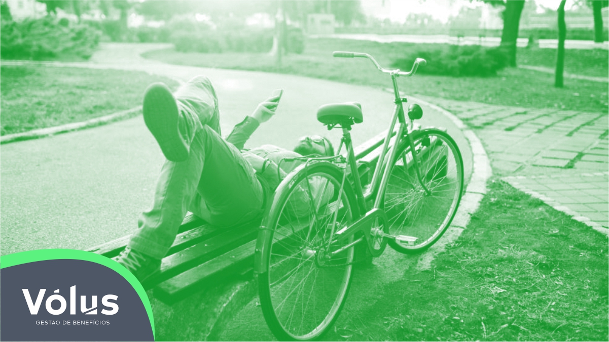 Pessoa em parque sentada ao lado de bicicleta. Imagem ilustrativa para texto o que é mobilidade.